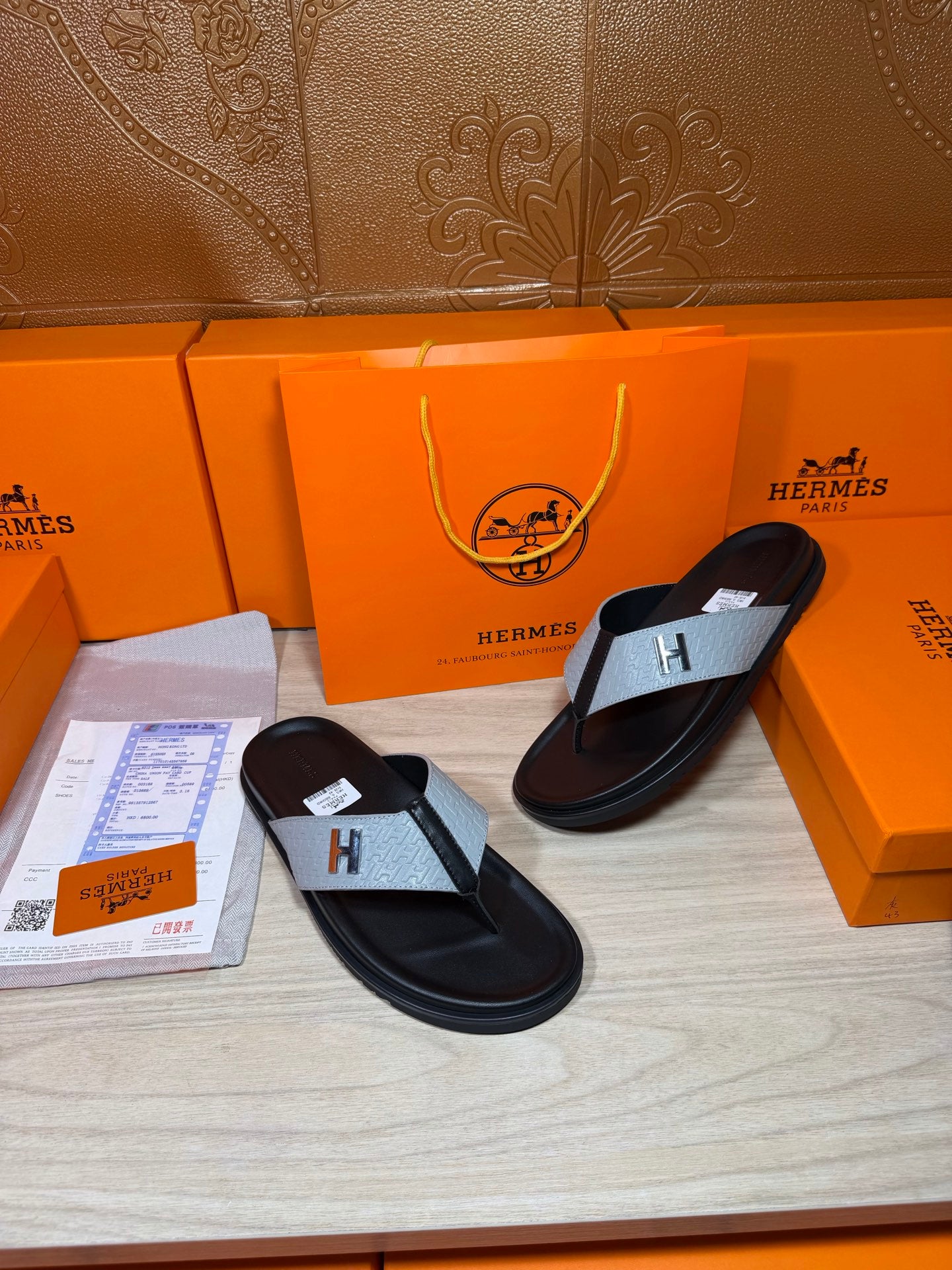 Black thong sandals with light gray H straps shown side by side
