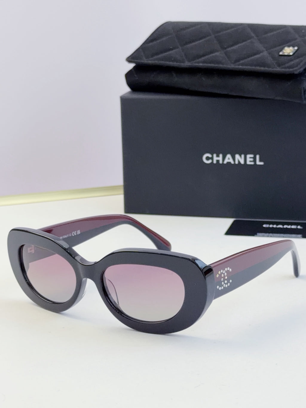 Chanel cat-eye sunglasses with dark frames and light pink tinted lenses