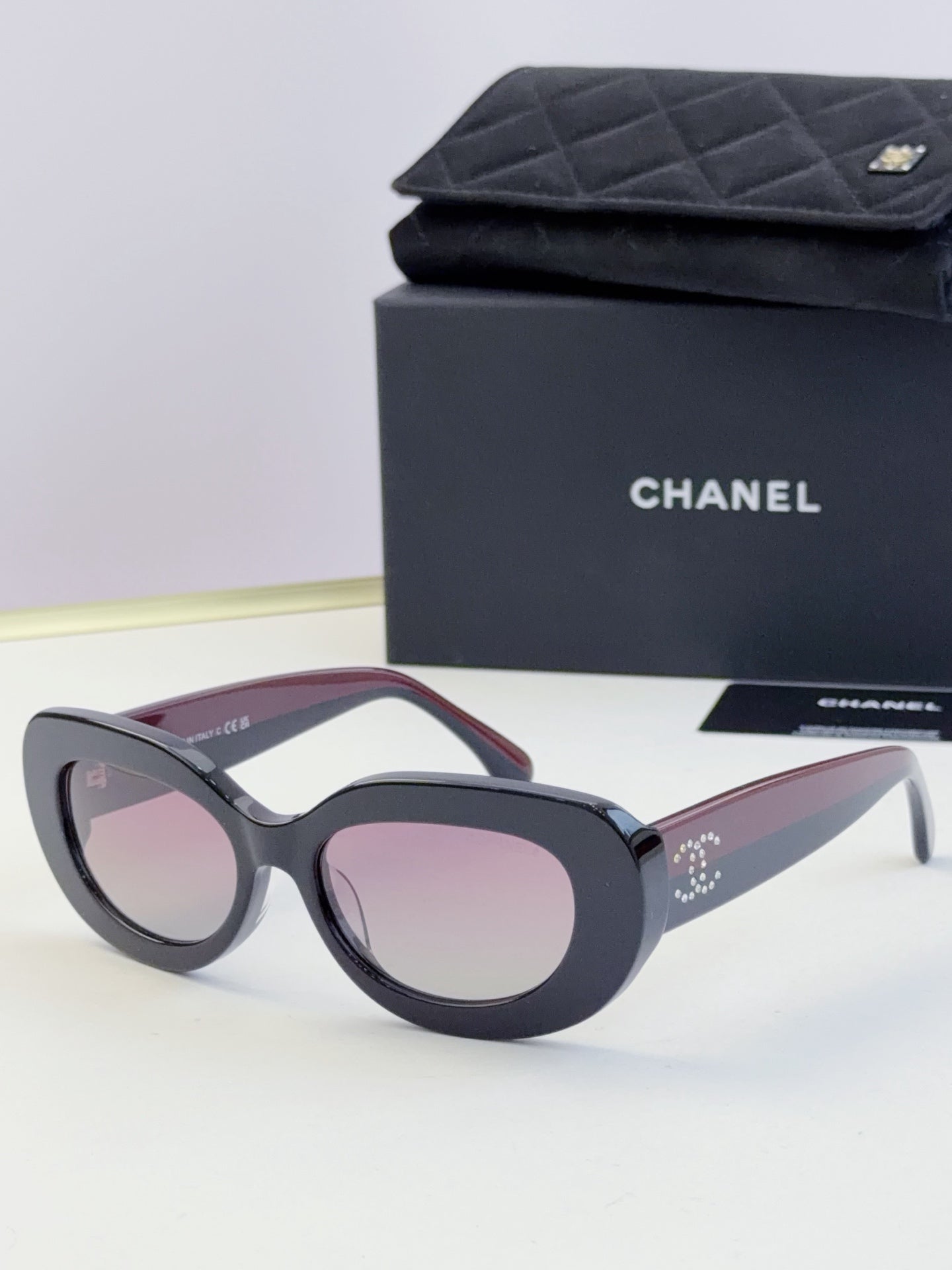 Chanel cat-eye sunglasses with dark frames and light pink tinted lenses