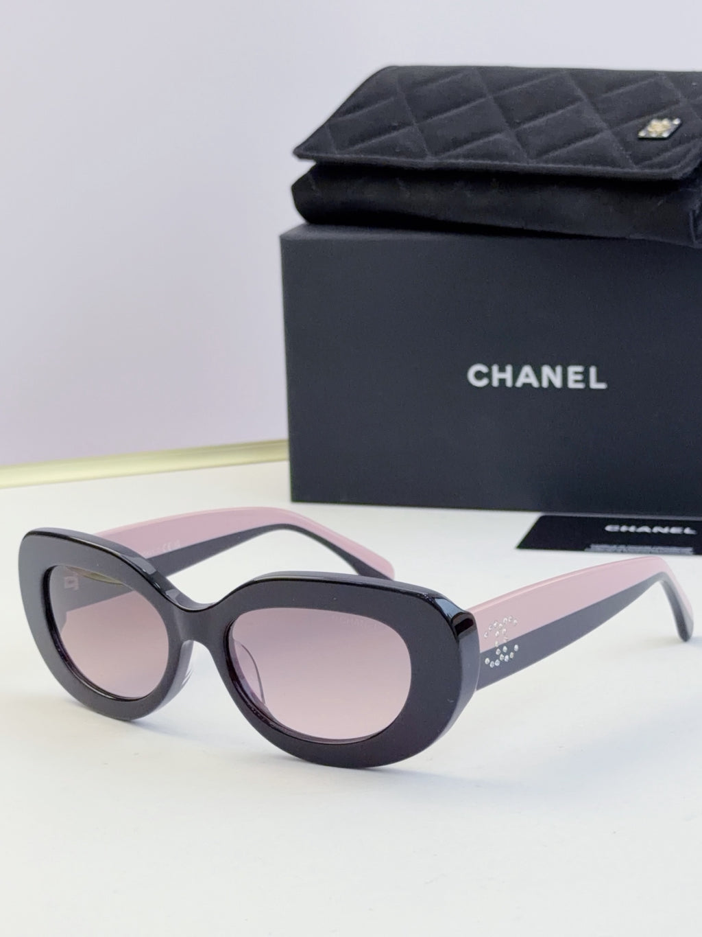 Chanel cat-eye sunglasses with dark frames and pale pink tinted lenses