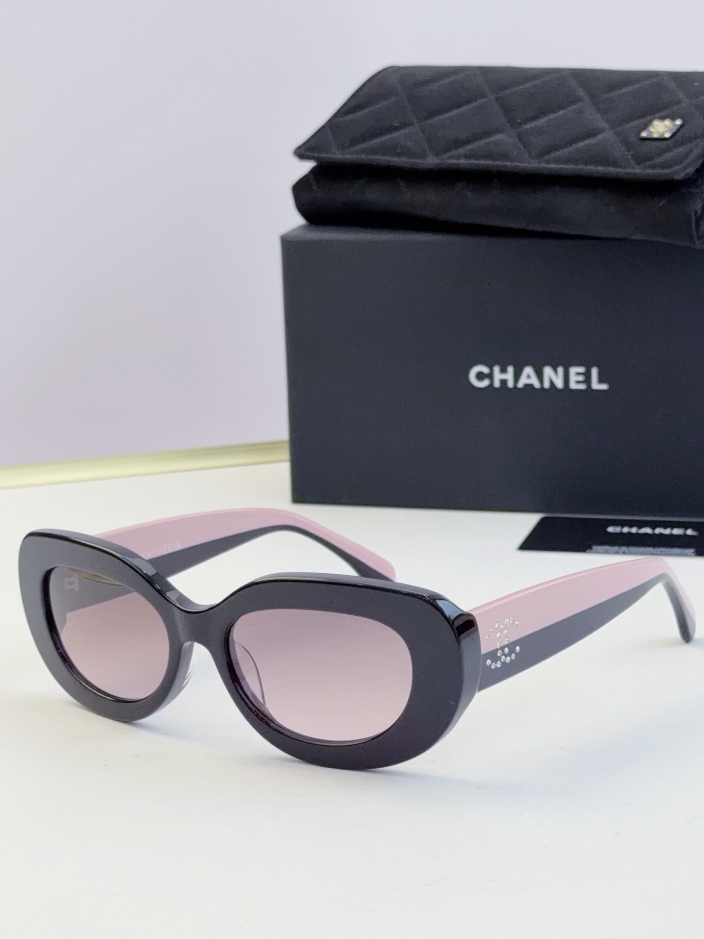 Chanel cat-eye sunglasses with dark frames and pale pink tinted lenses