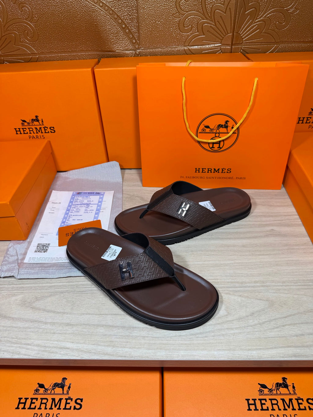 Brown leather flip-flop sandals with H strap detail, side-by-side