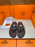 Brown leather flip-flop sandals with dark H strap detail on upper