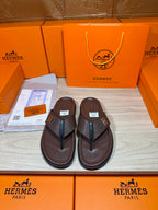 Brown leather flip-flop sandals with dark H strap detail on upper