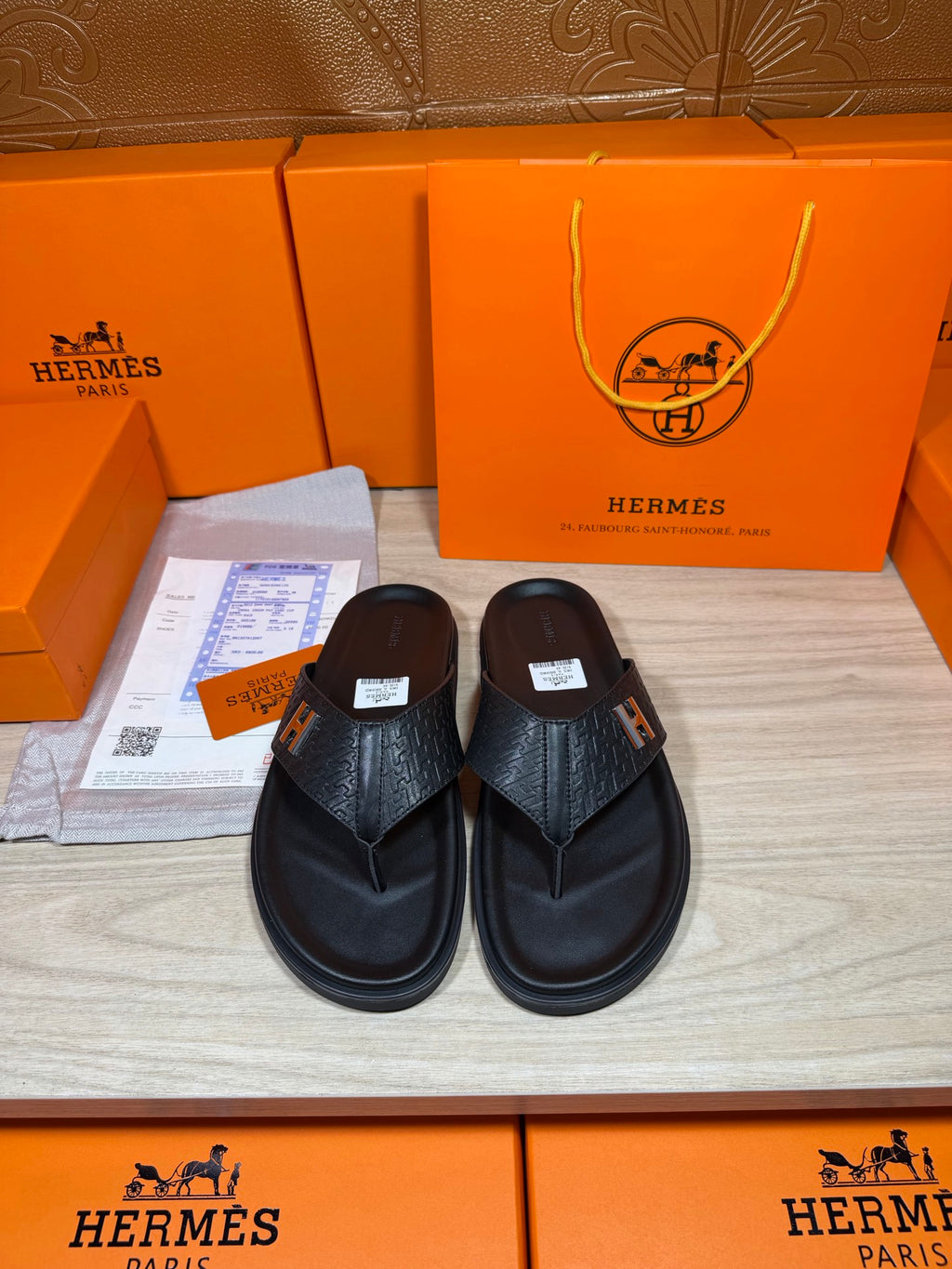 Black leather slide sandals with H logo strap and textured upper