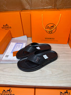 Black leather slide sandals, H logo strap detail, textured footbed and sole