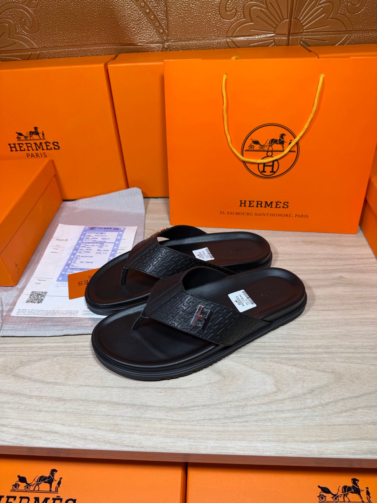 Black leather slide sandals, H logo strap detail, textured footbed and sole