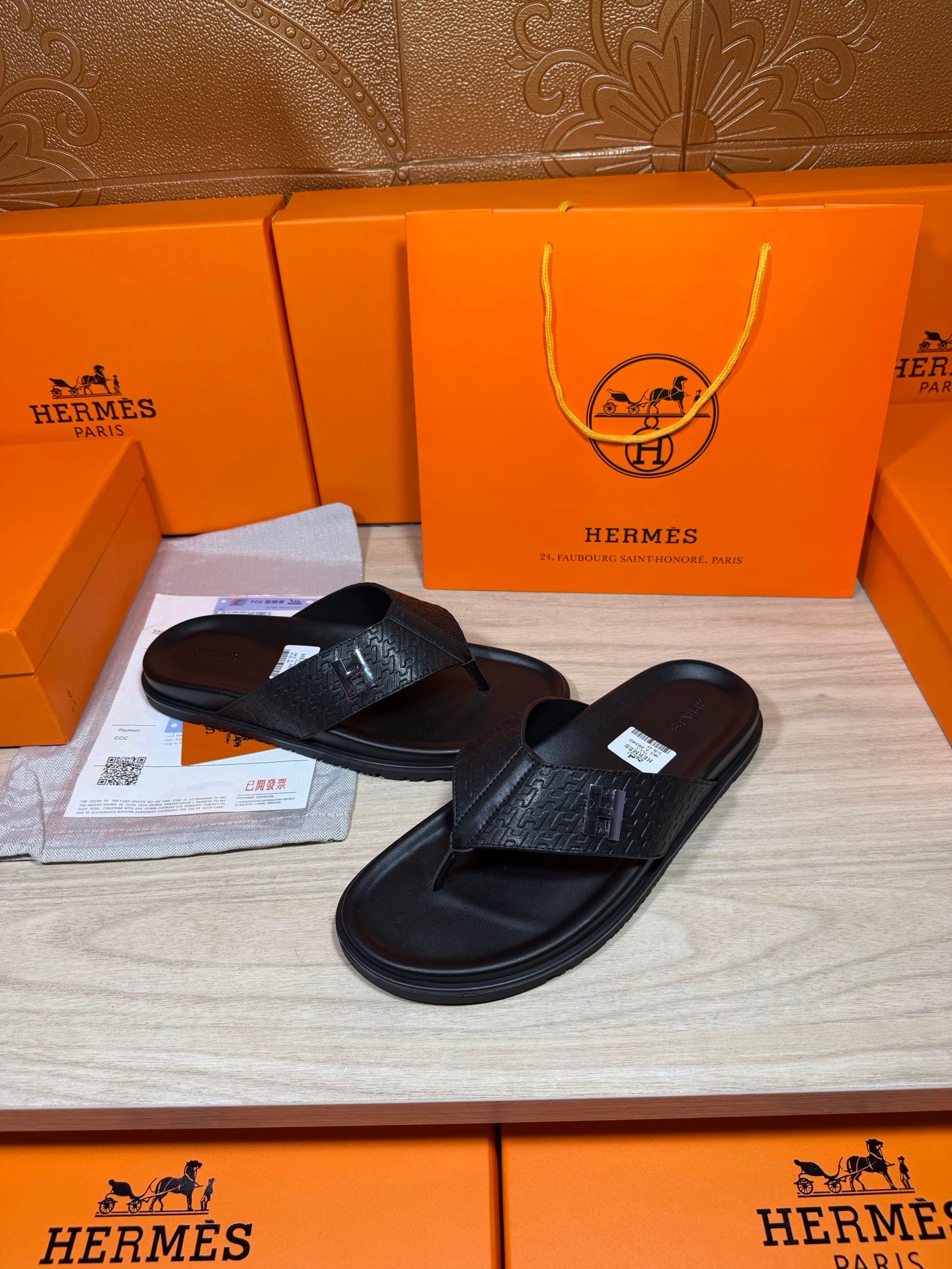 Black leather slide sandals with H logo on the strap and grippy flat sole