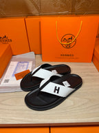 Hermes sandals, black footbed with white cross strap and H logo on toe thong.