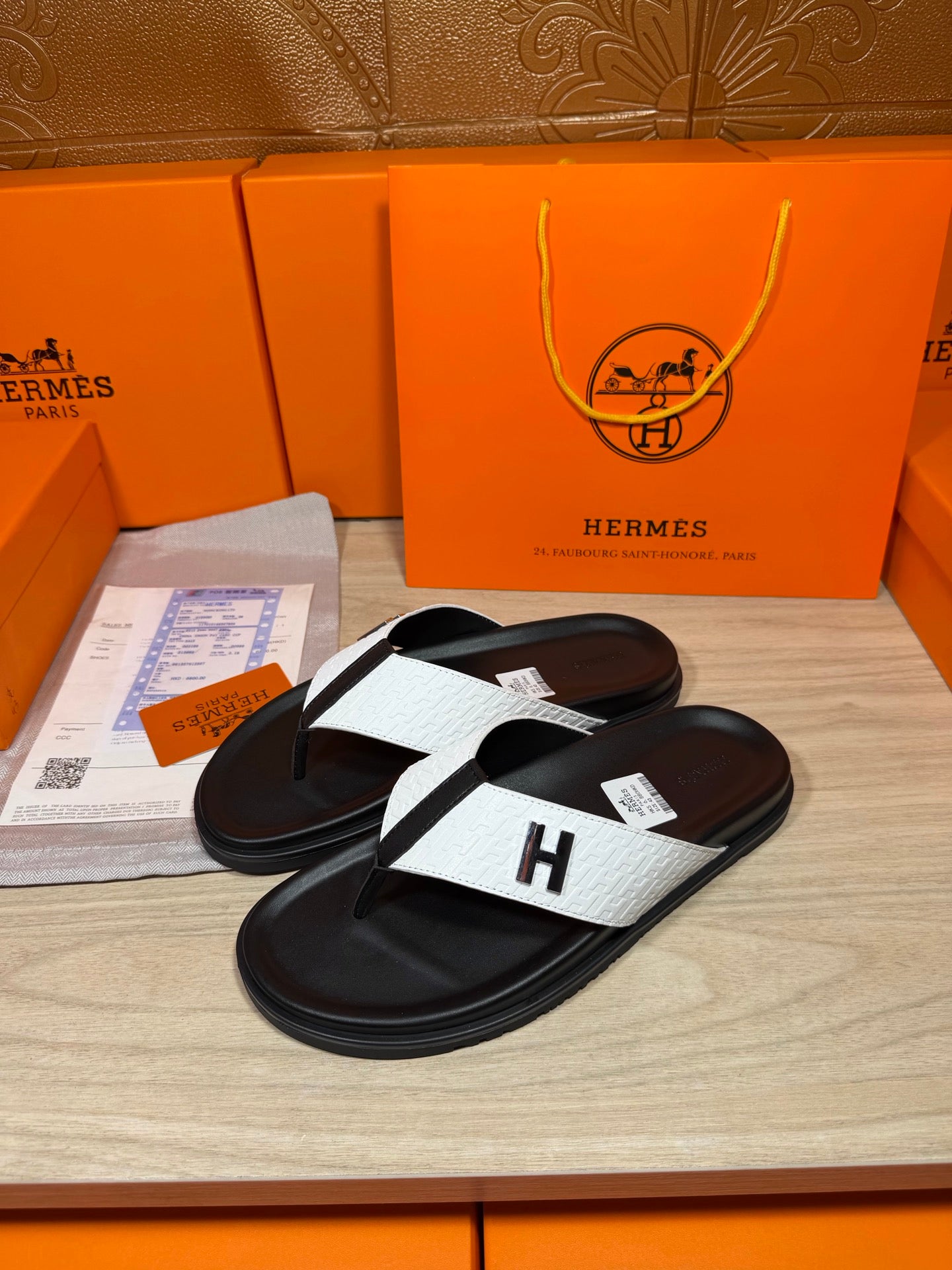 Hermes sandals, black footbed with white cross strap and H logo on toe thong.