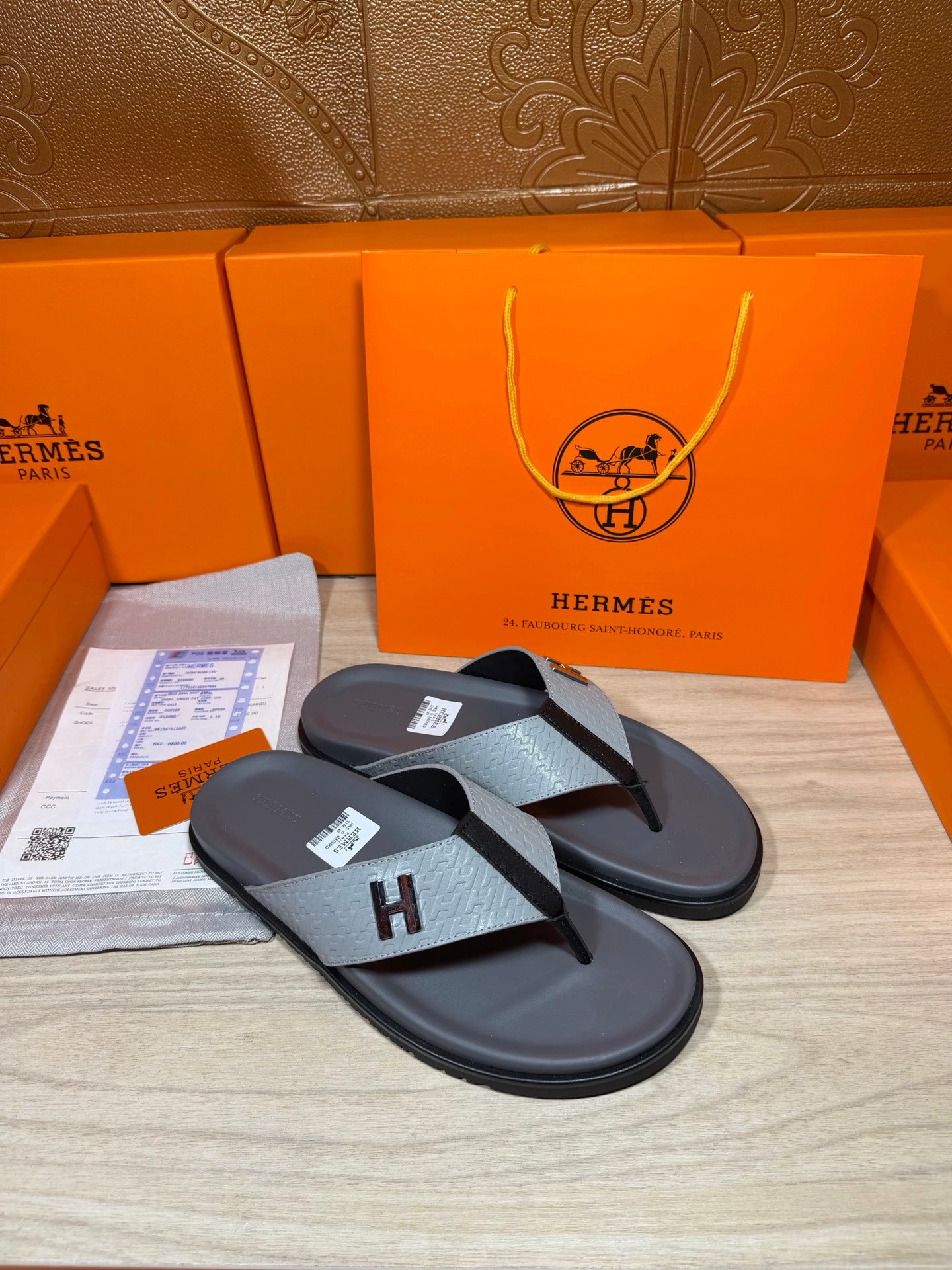 Hermes flip-flop sandals pair, black soles with gray H straps