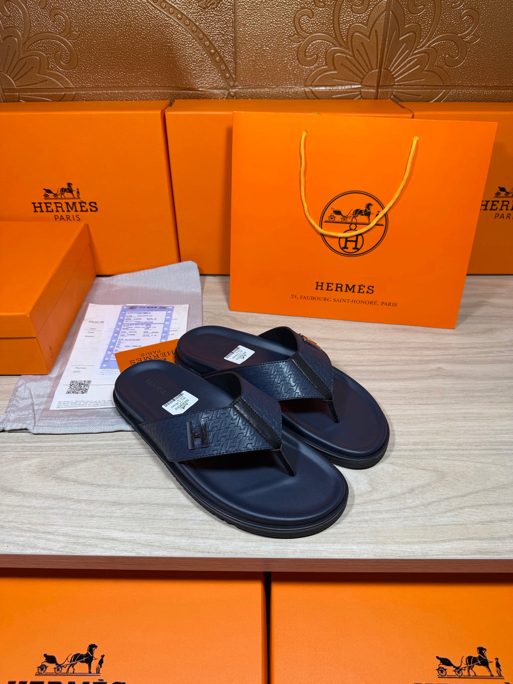 Hermes leather sandals in dark blue, front view with H emblem on toe straps