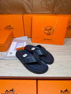 Hermes leather sandals in dark blue, front view with H emblem on toe straps
