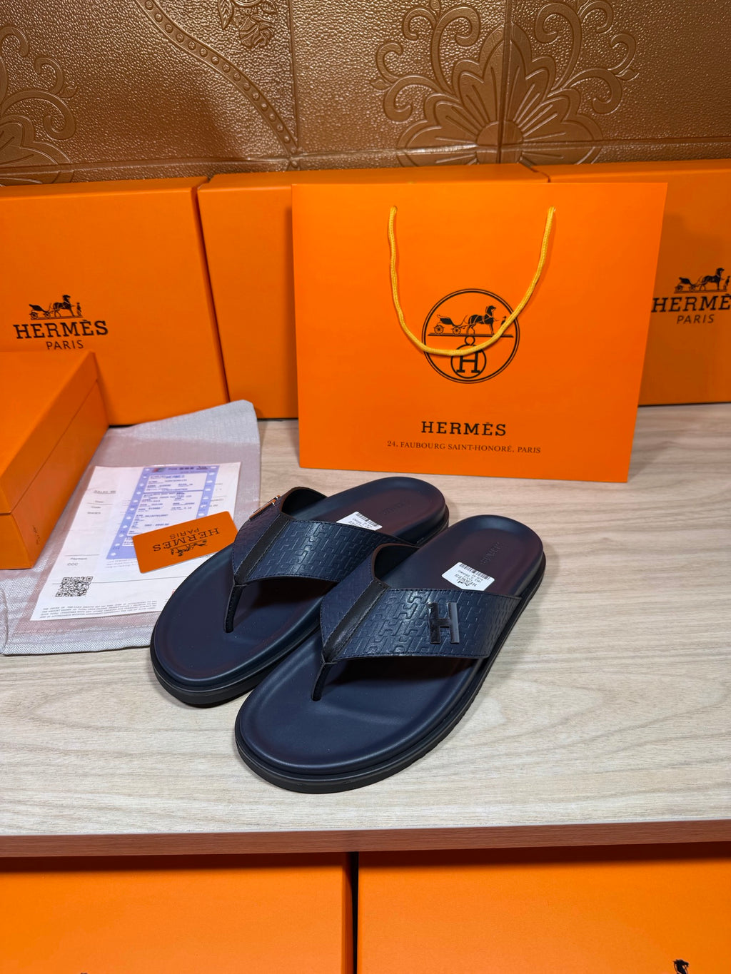 Hermes leather flip-flops in dark blue with textured straps, pair angled side view