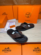 Brown and black H-logo thong sandals, angled pair with embossed strap detail