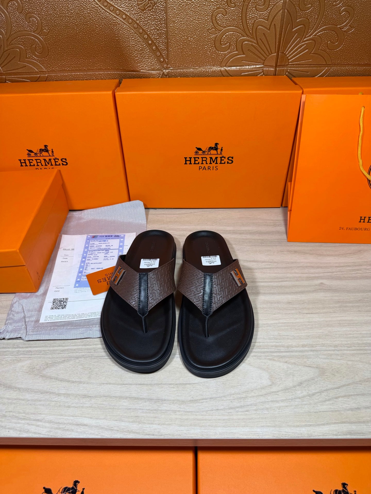 Brown and black H-logo thong sandals with textured strap and black footbed