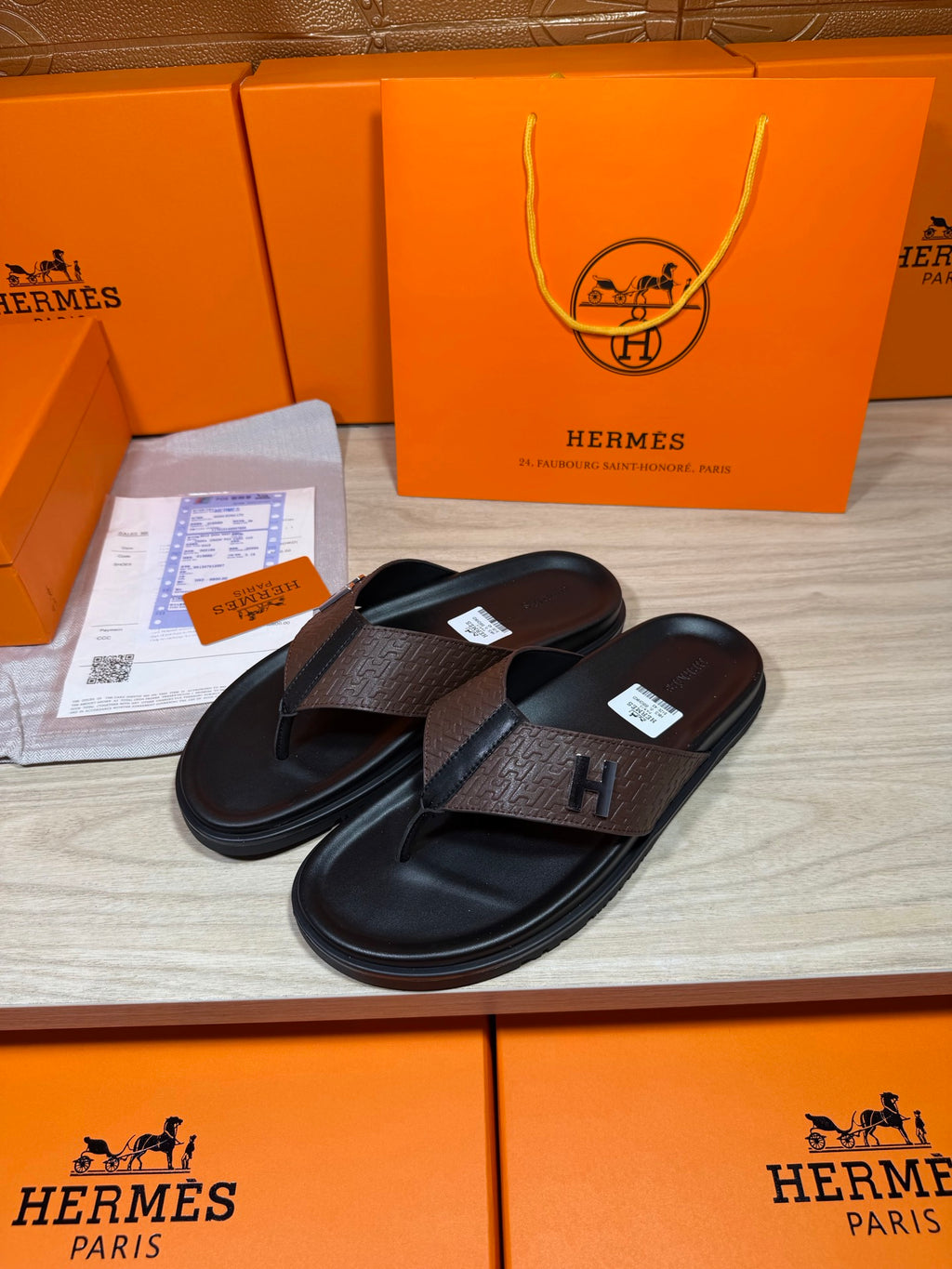 Brown and black H-logo thong sandals, single pair view with toe divider