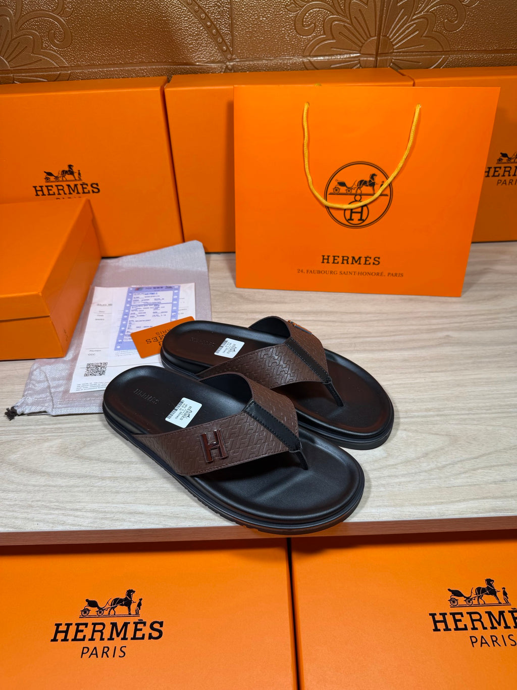 Brown and black H-logo thong sandals with slim black sole and dark footbed