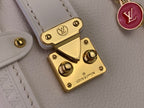 Louis Vuitton handbag hardware close-up: gold lock plate with LV emblem