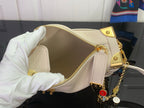Louis Vuitton handbag interior with gold zipper, light pink leather, and chain charm