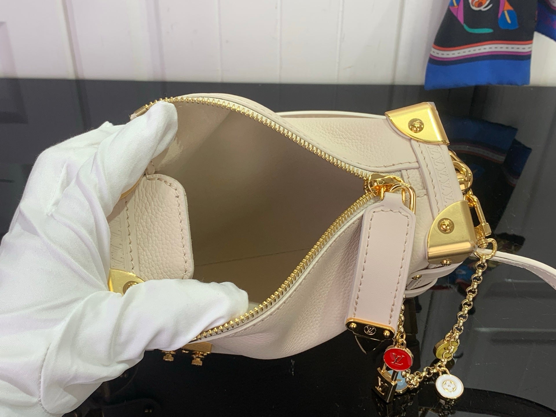 Louis Vuitton handbag interior with gold zipper, light pink leather, and chain charm
