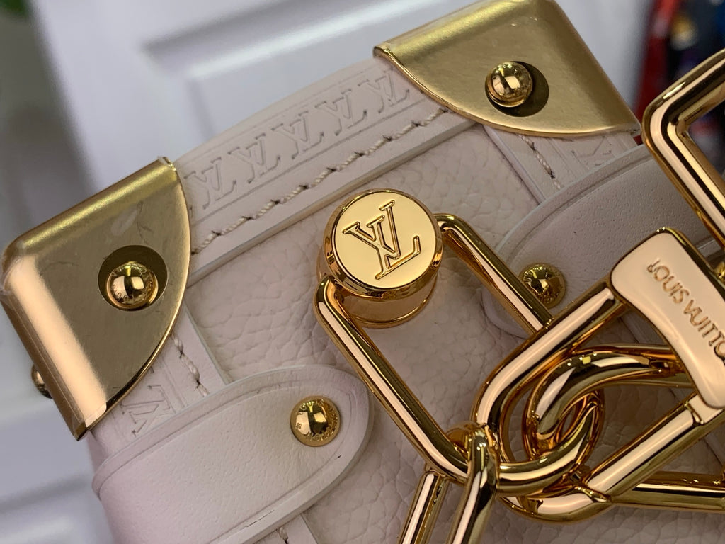 Louis Vuitton bag hardware with gold clasp and LV logo on light leather