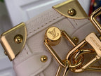 Louis Vuitton bag hardware with gold clasp and LV logo on light leather