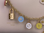 Louis Vuitton bag with pale pink leather, gold chain, padlock and round charms