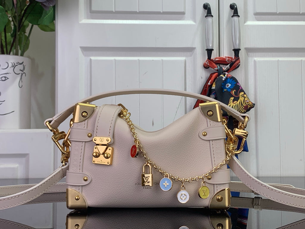 Louis Vuitton handbag in light pink leather with gold studs, lock charm, and shoulder strap