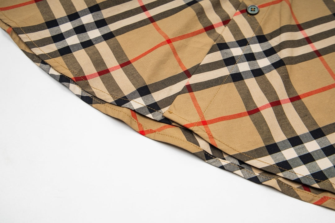 Plaid long-sleeve shirt fabric close-up at curved hem edge