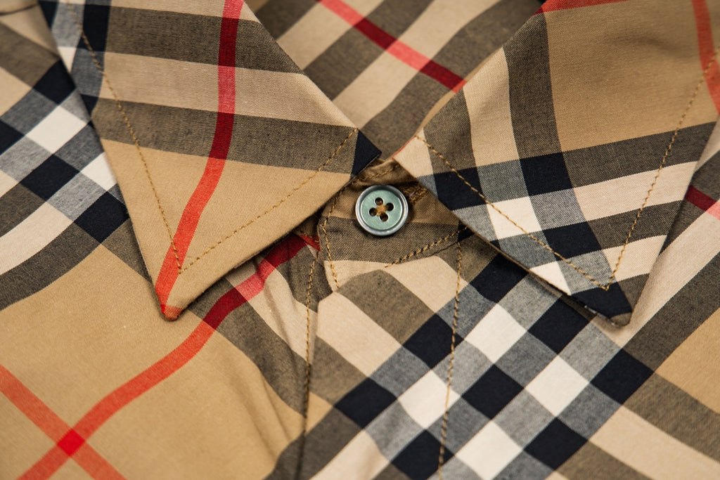 Plaid long-sleeve shirt detail: round buttons and stitched pocket area