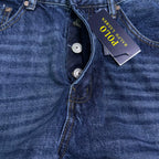 Blue denim jeans close-up of button fly and coin pocket.