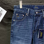 Blue denim jeans front pockets with coin pocket and button details.