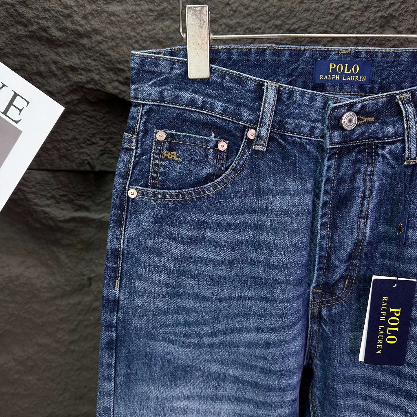 Blue denim jeans front pockets with coin pocket and button details.