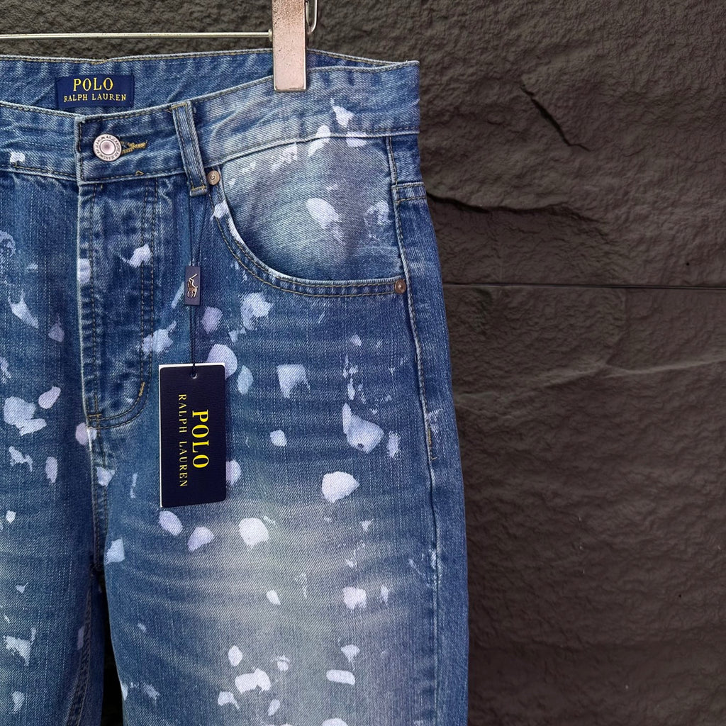 Blue denim jeans with white speckle print, front yoke details, hanging POLO tag.