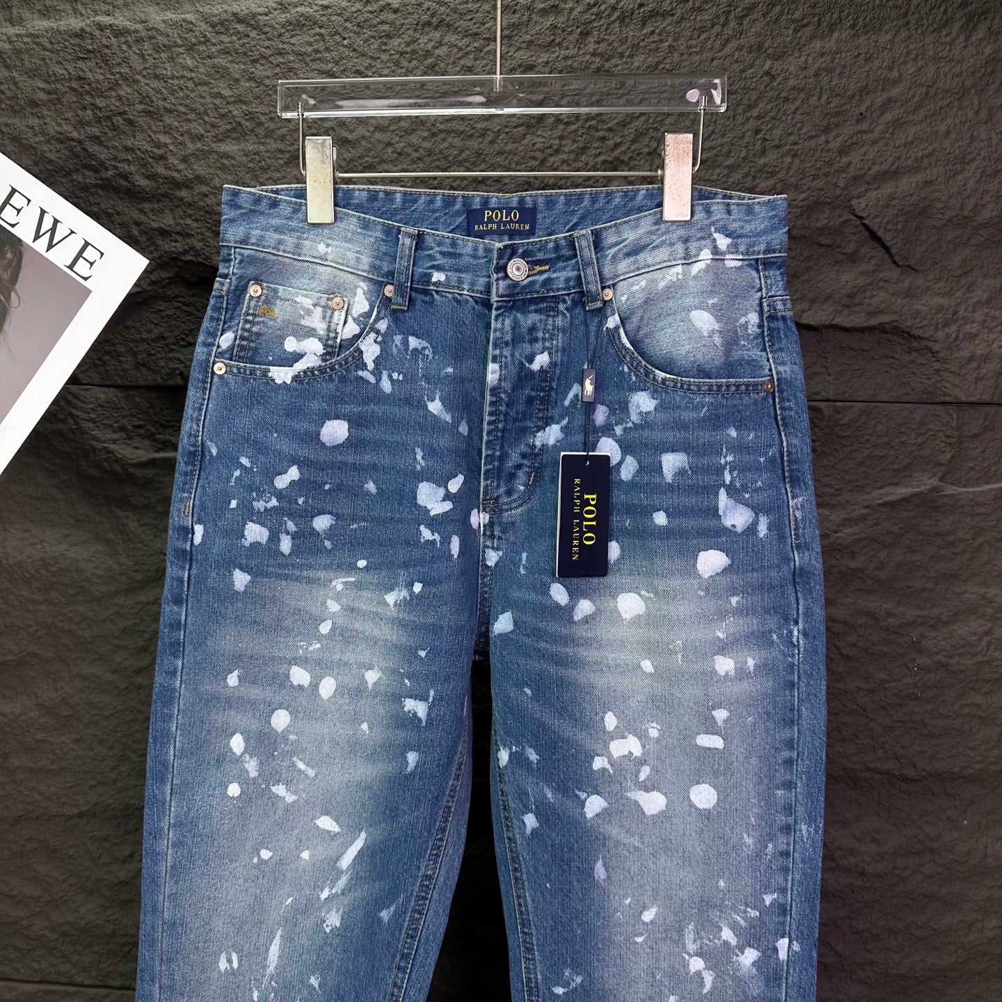 Blue denim jeans with white speckle print, POLO label on waistband, straight legs.