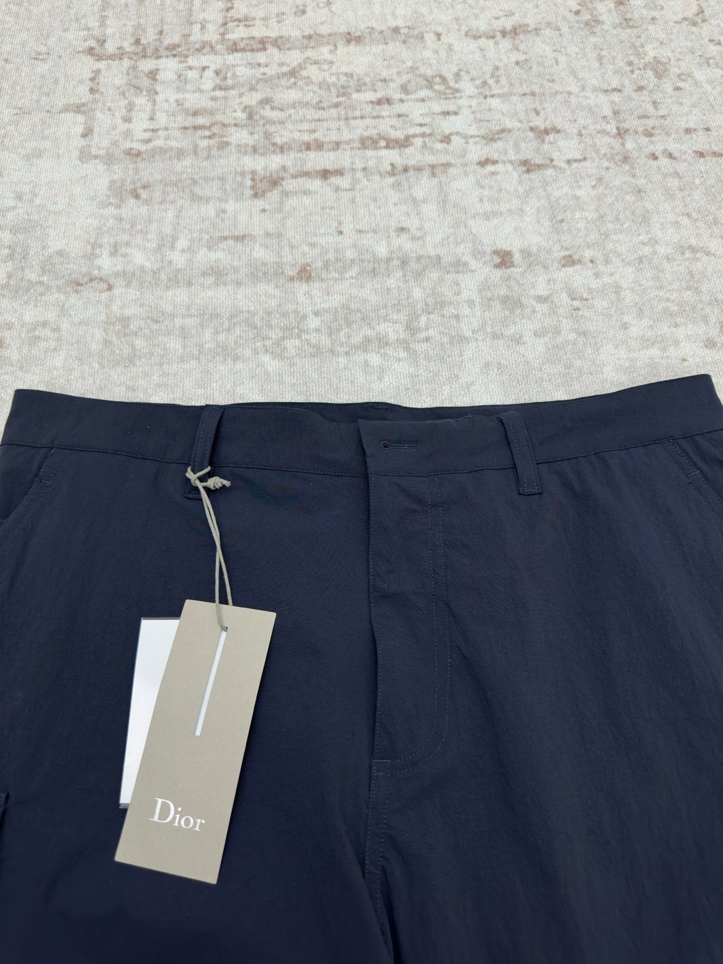 Dior navy pants with drawstring waist and hanging brand tag