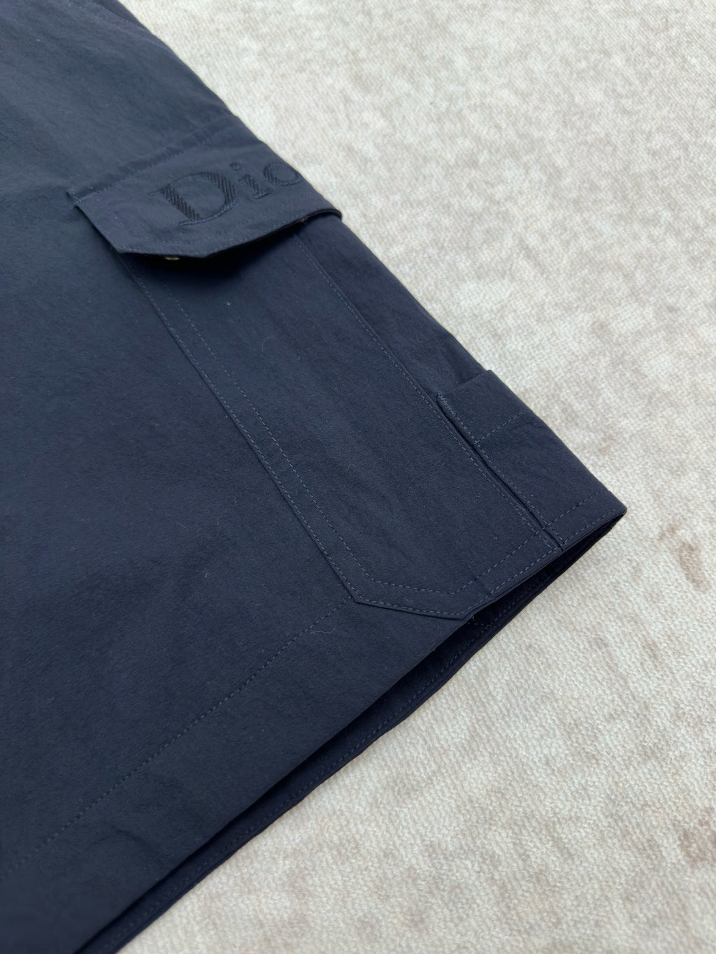 Dior navy cargo pant leg with stitched pocket and fold seam