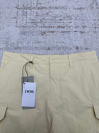 Light yellow shorts with drawstring waist and Dior hang tag