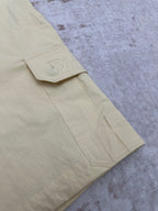 Light yellow shorts with stitched cargo pocket and D embroidery on hem