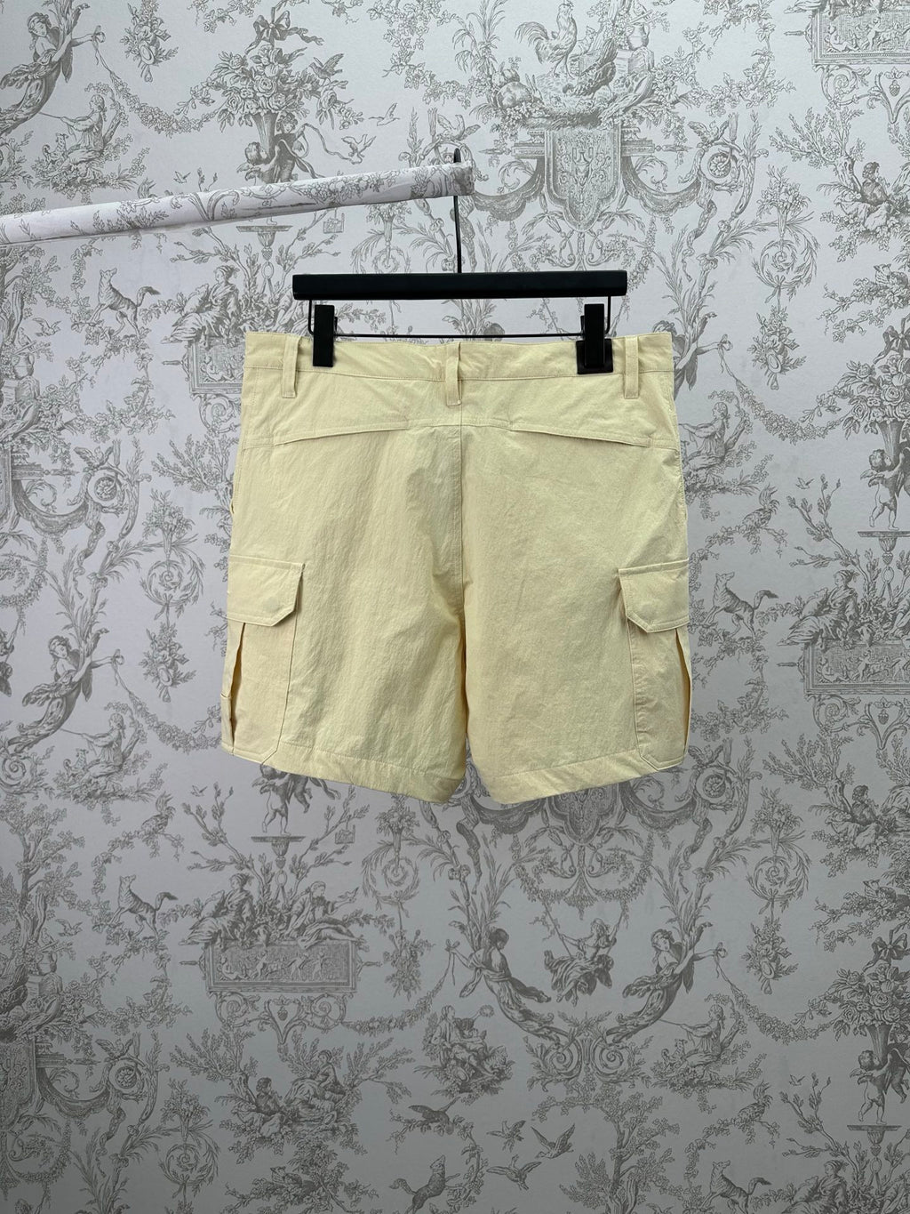 Light yellow cargo shorts with two side flap pockets and belt loops