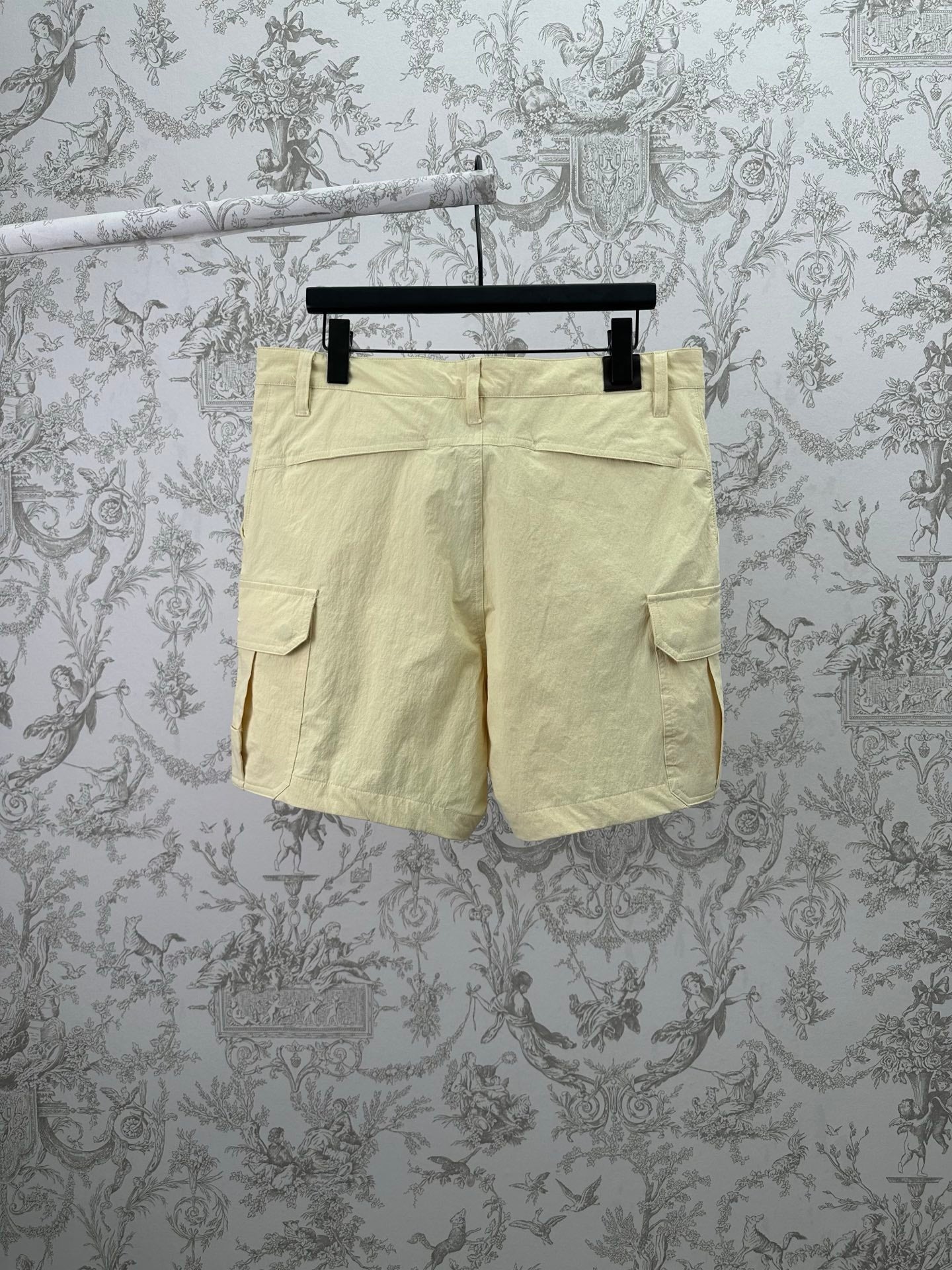 Light yellow cargo shorts with two side flap pockets and belt loops