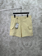 Light yellow cargo shorts with button closure and two side flap pockets