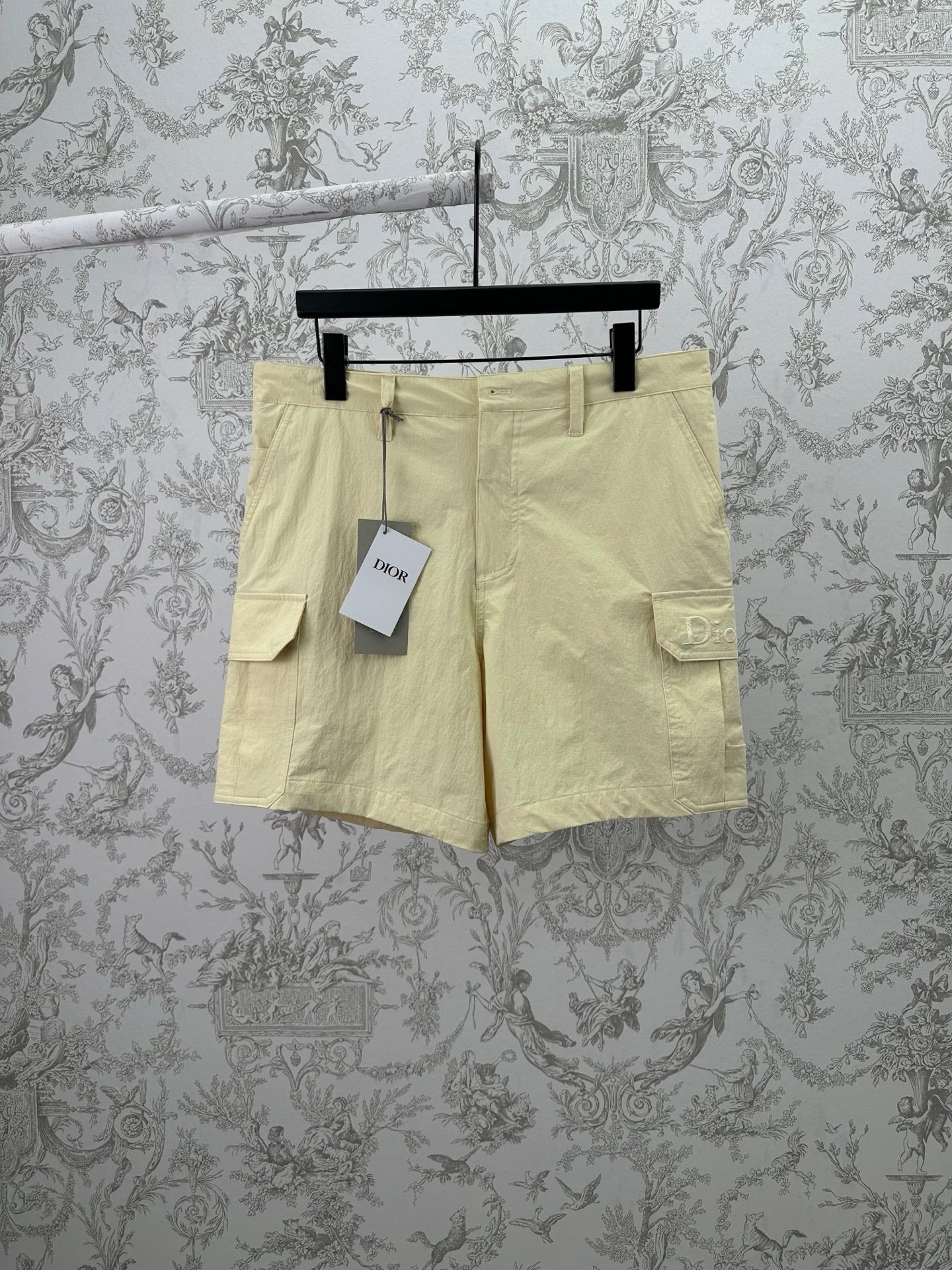 Light yellow cargo shorts with button closure and two side flap pockets