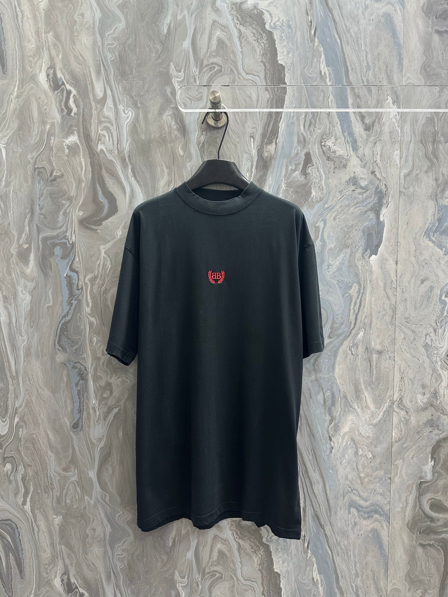 Black short-sleeve T-shirt with small red logo on chest