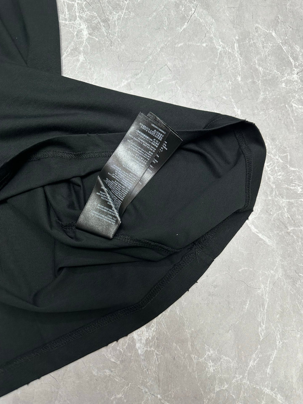 Black short-sleeve T-shirt side close-up with care label