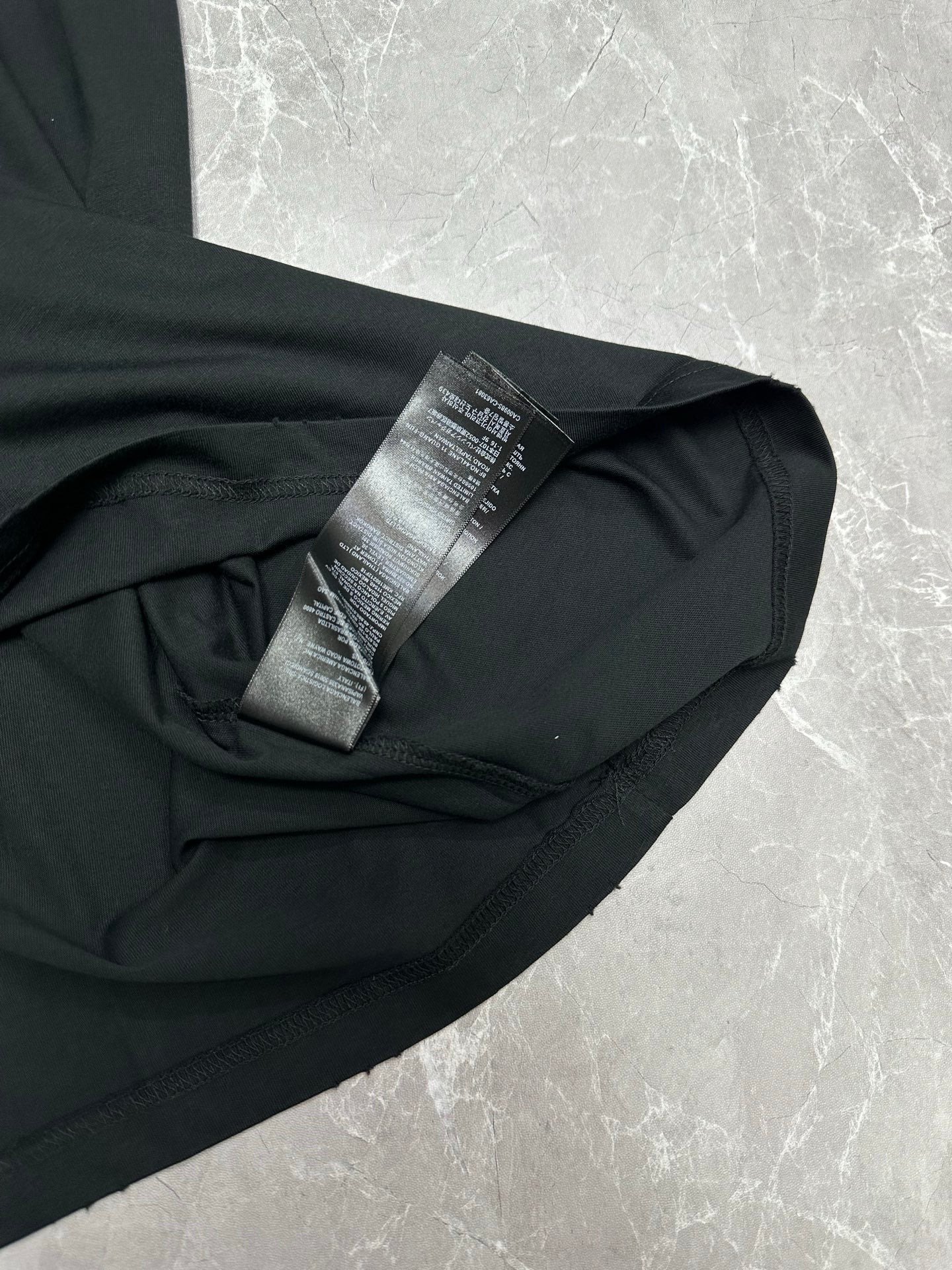 Black short-sleeve T-shirt side close-up with care label
