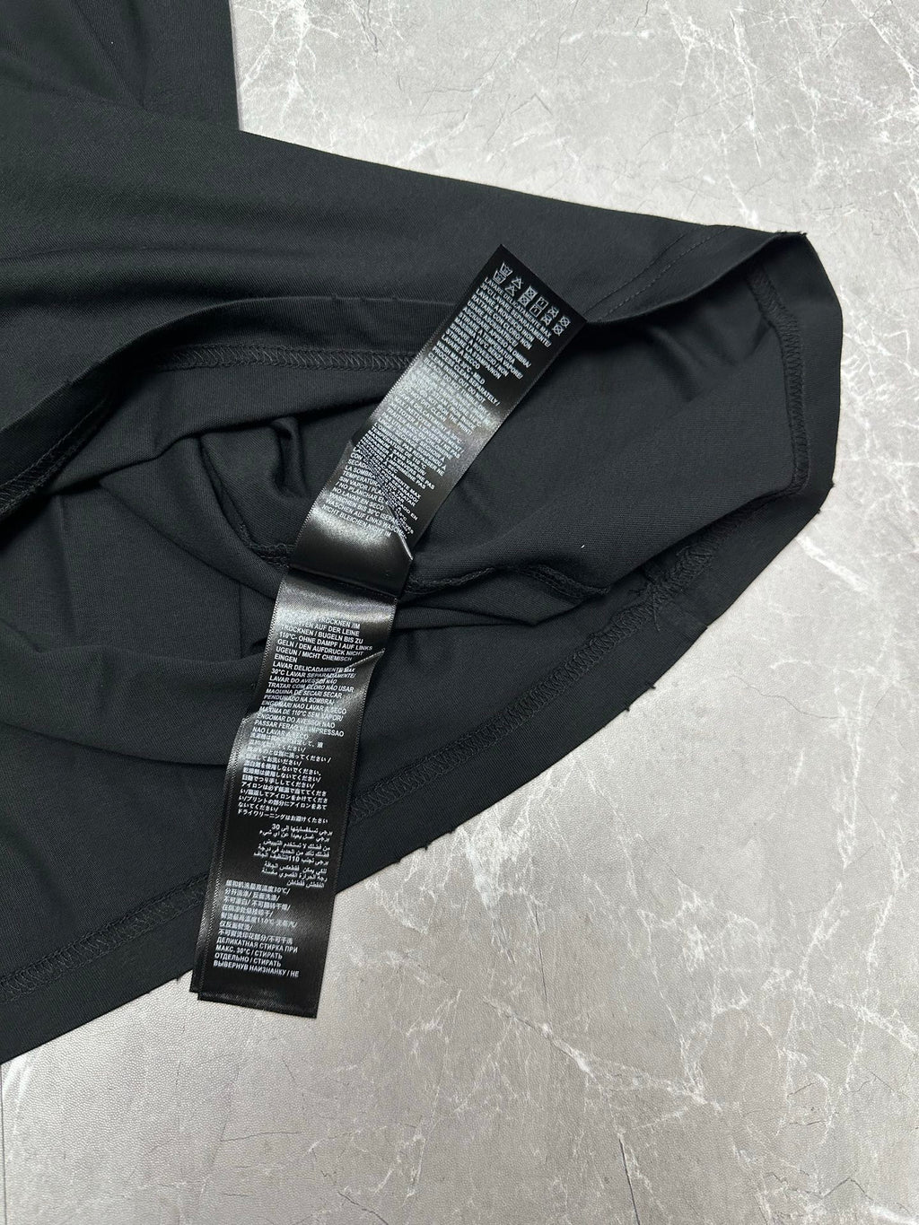 Black short-sleeve T-shirt with folded sleeve care label