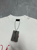 White crewneck T-shirt with black Balenciaga tag hanging at collar
