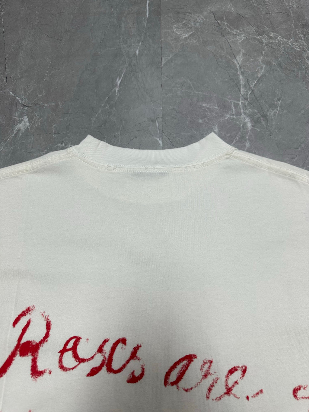 White T-shirt back close-up of red script logo text